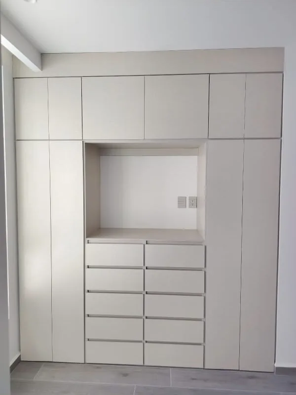 Obra real: cajonera de diez cajones con nicho para TV y closets laterales a la medida